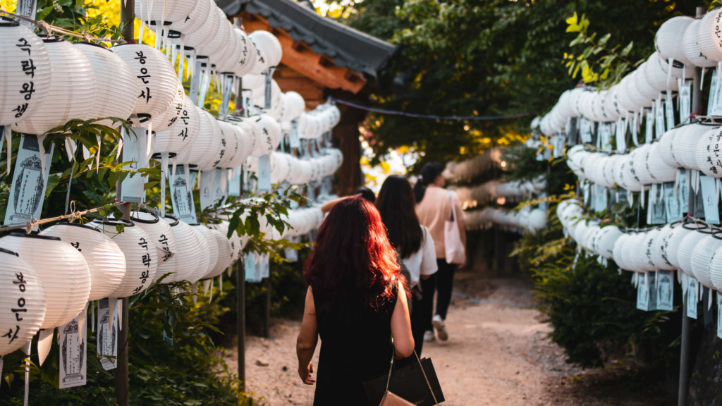 Person walking along white Korean lanterns