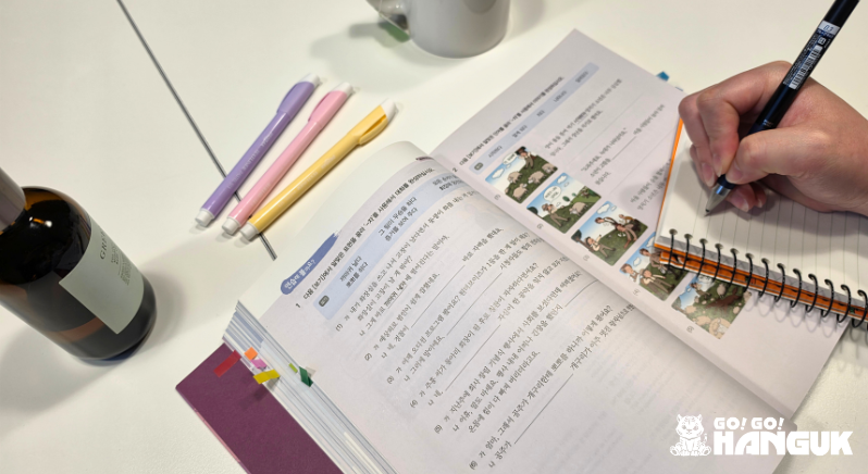 Person studying Korean on language books