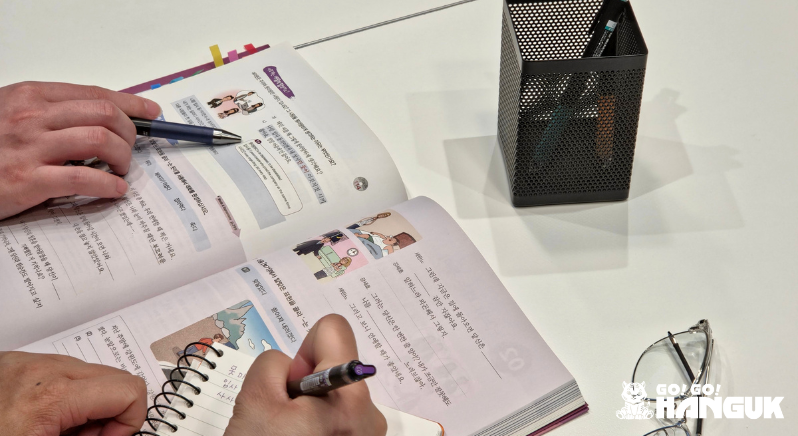 Hands on a Korean language book taking notes