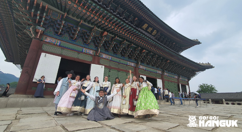 People wearing the hanbok in front of a Korean palace gate during a Korean Study trip