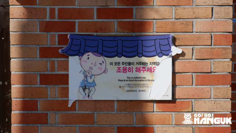 Cartello che indica di fare silenzio su un muro del villaggio hanok in Corea