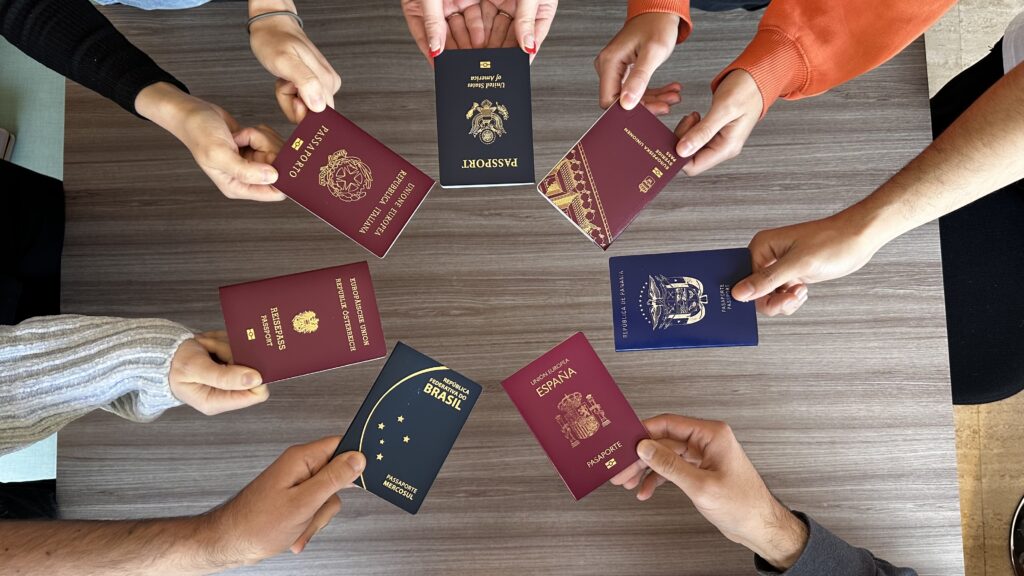Mani che tengono 7 passaporti di 7 paesi diversi