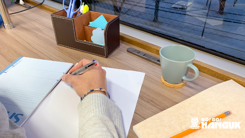 Person writing notes on a white paper