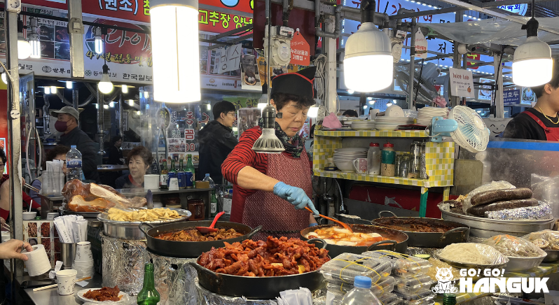 Mujer cocinando en un mercado local.