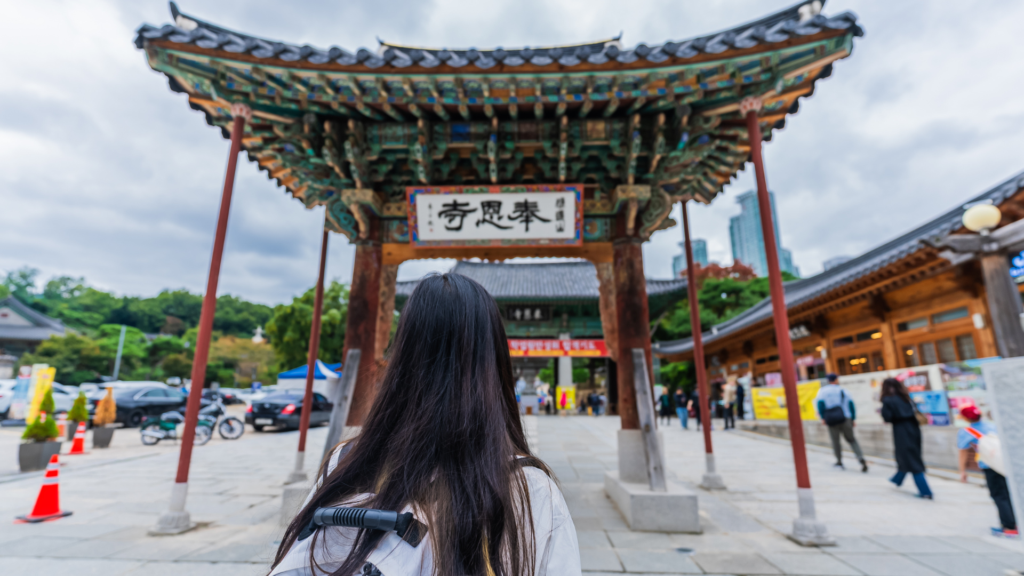 Person with a backpack in front of a Korean gate