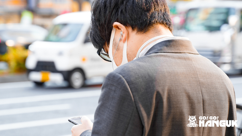韓国の街中でスマートフォンを使う男性